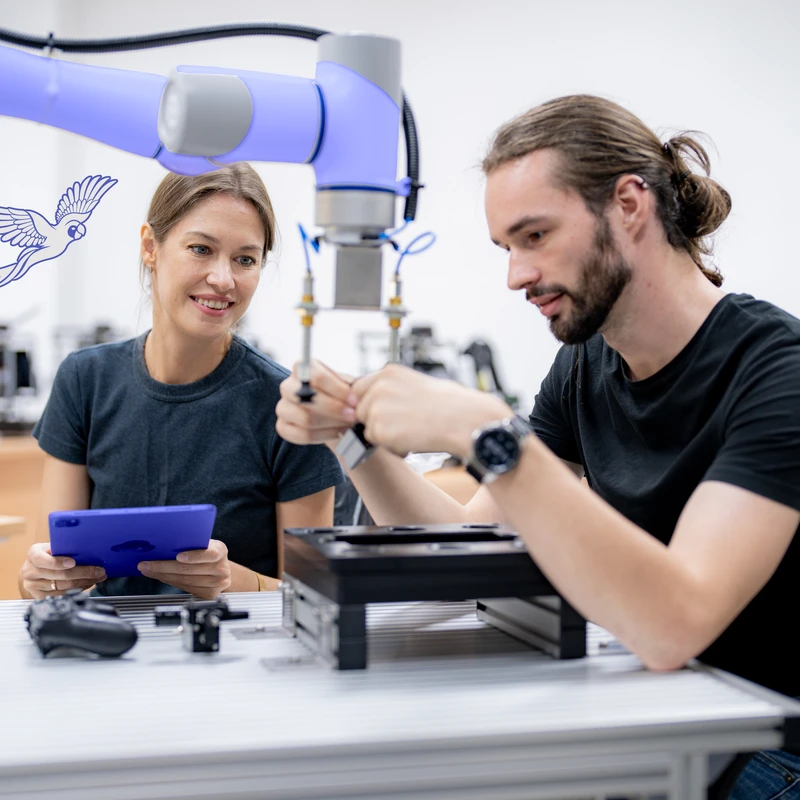 Deux ingénieurs mettant au point un bras robotisé